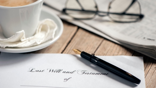 Last Will and Testament with a cup of coffee, pen, paper and glasses